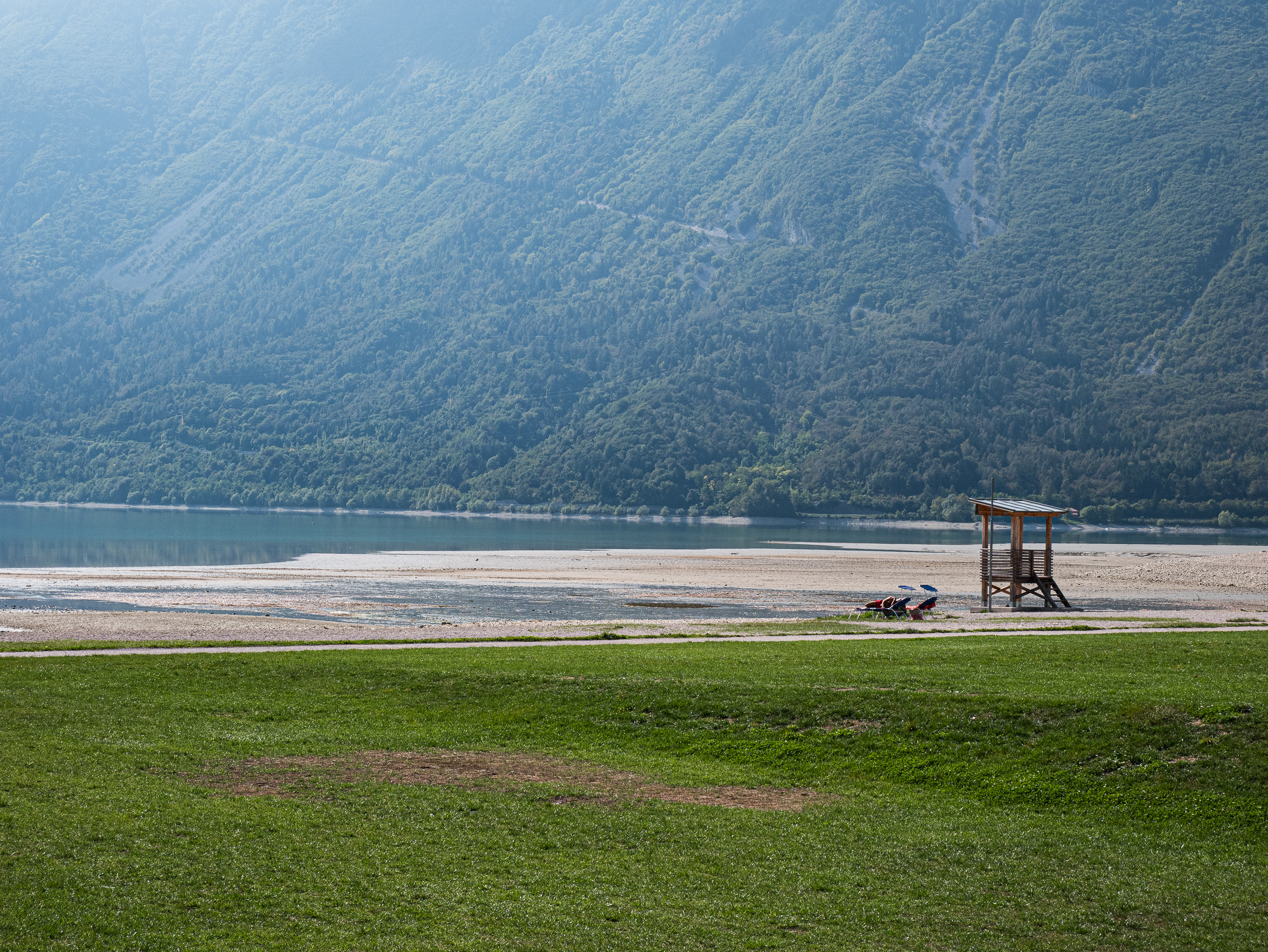 Der Strand am Lago di Santa Croce im Morgendunst